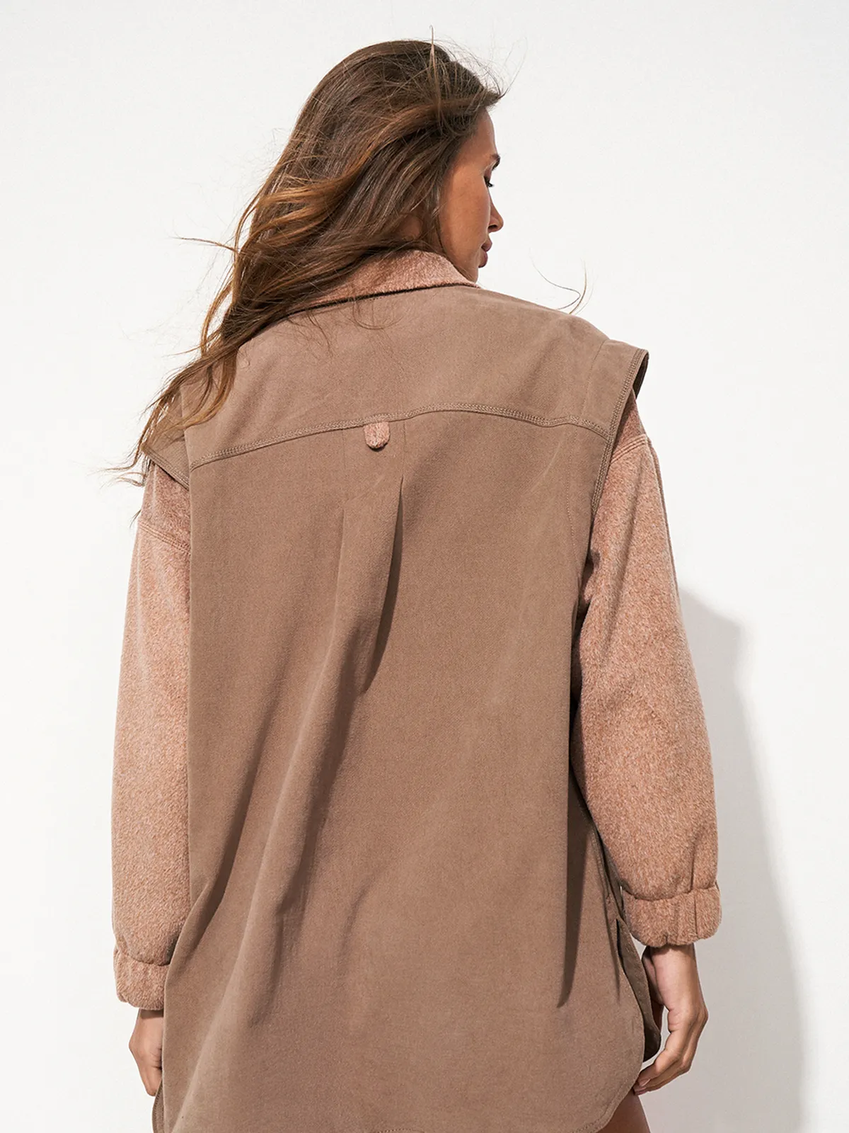 Улыбающаяся женщина в коричневой рубашке оверсайз SHIRT COSY CHOCOLATE от MOODSTORIES с фактурными рукавами и воротником.