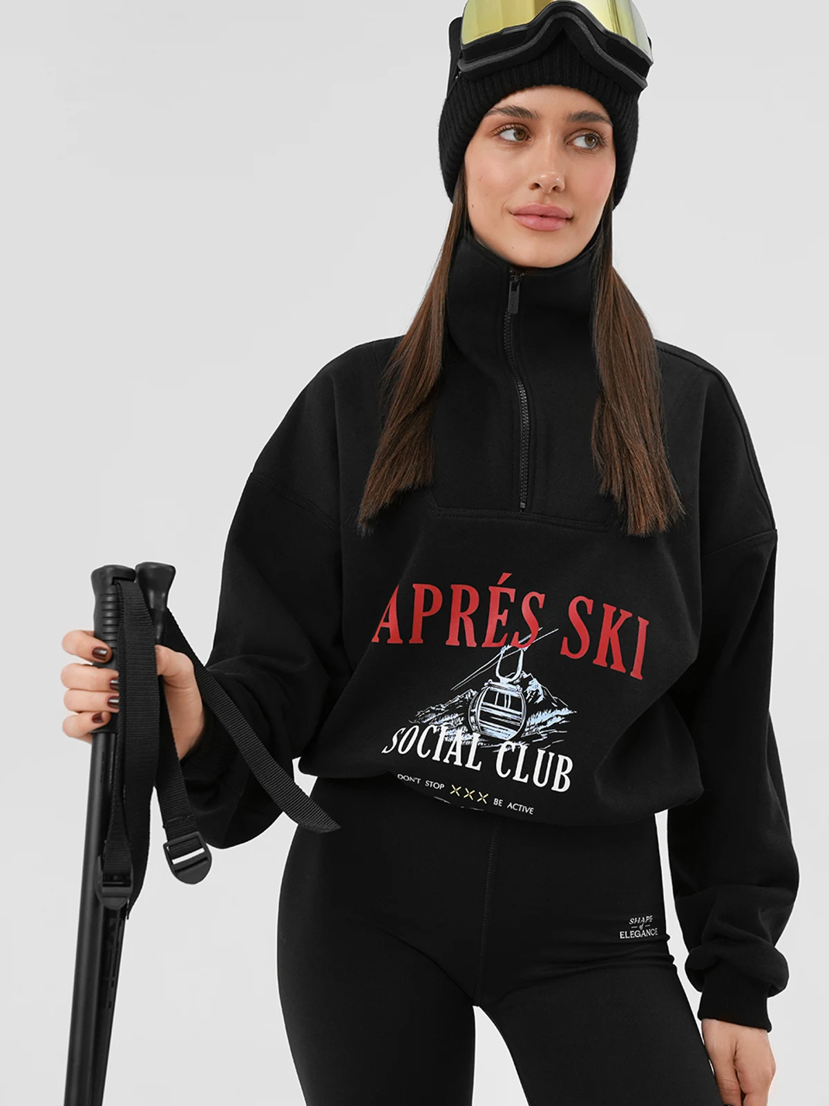 Дівчина в чорному костюмі MOODSTORIES SUIT Le Club Après Ski: світшот з принтом та широкі штани з написом.