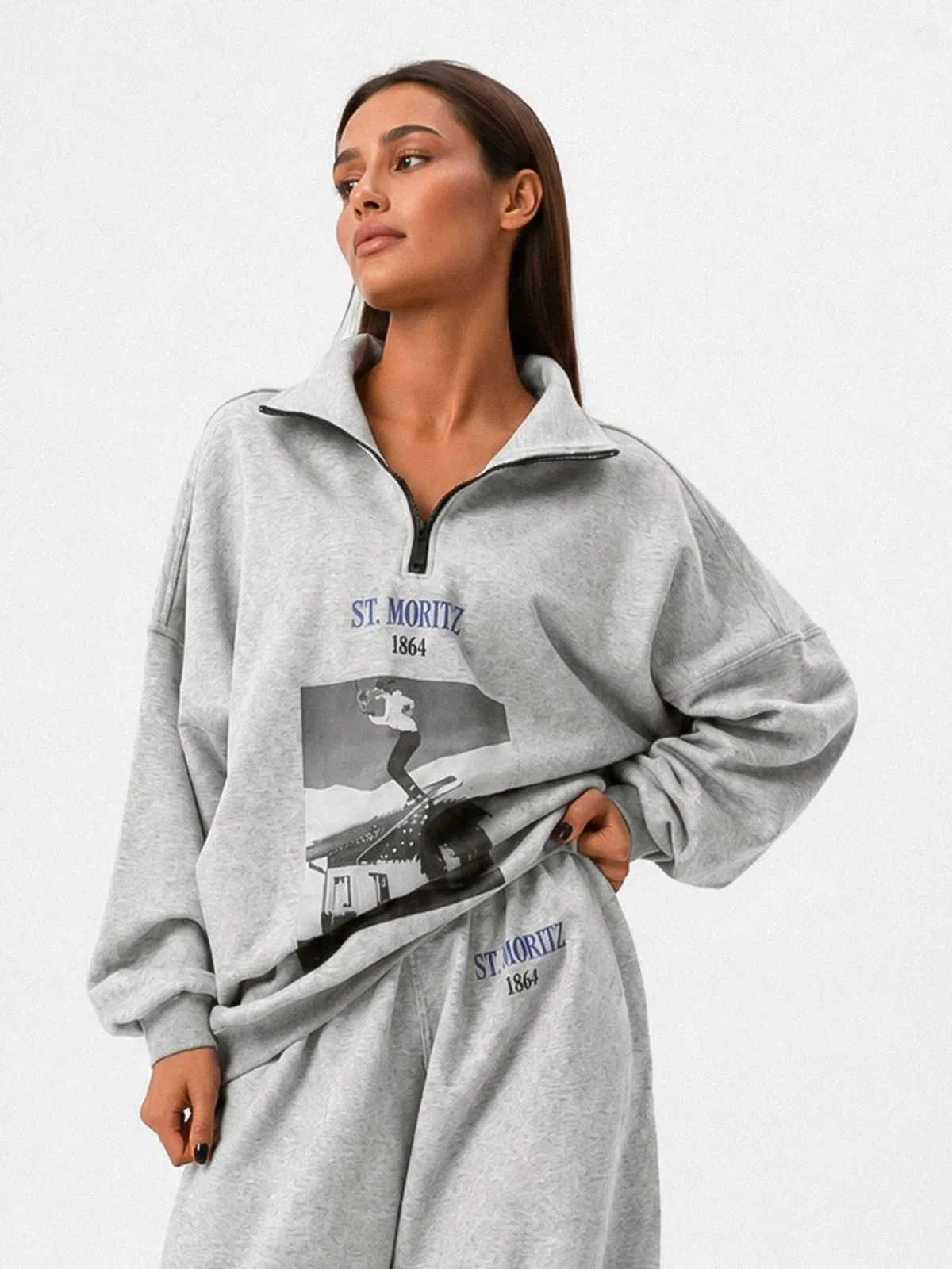 Модель в сером спортивном костюме MOODSTORIES SUIT ST. Moritz 1864, состоящем из оверсайз свитшота и широких брюк.