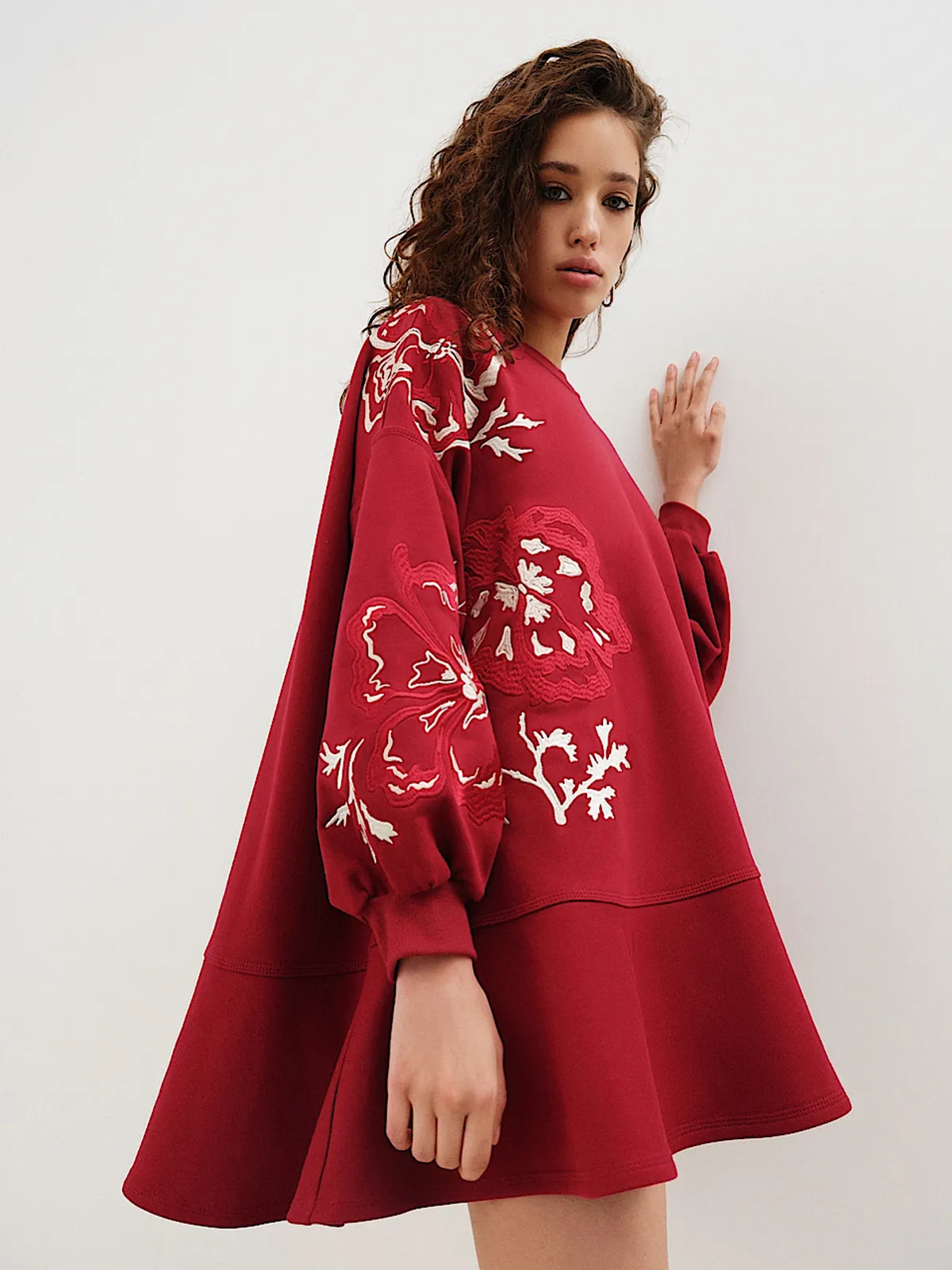 Модель у червоній сукні MOODSTORIES DRESS FLOWERS ON MARS з вишивкою на рукавах, вільного крою, довжина міні.