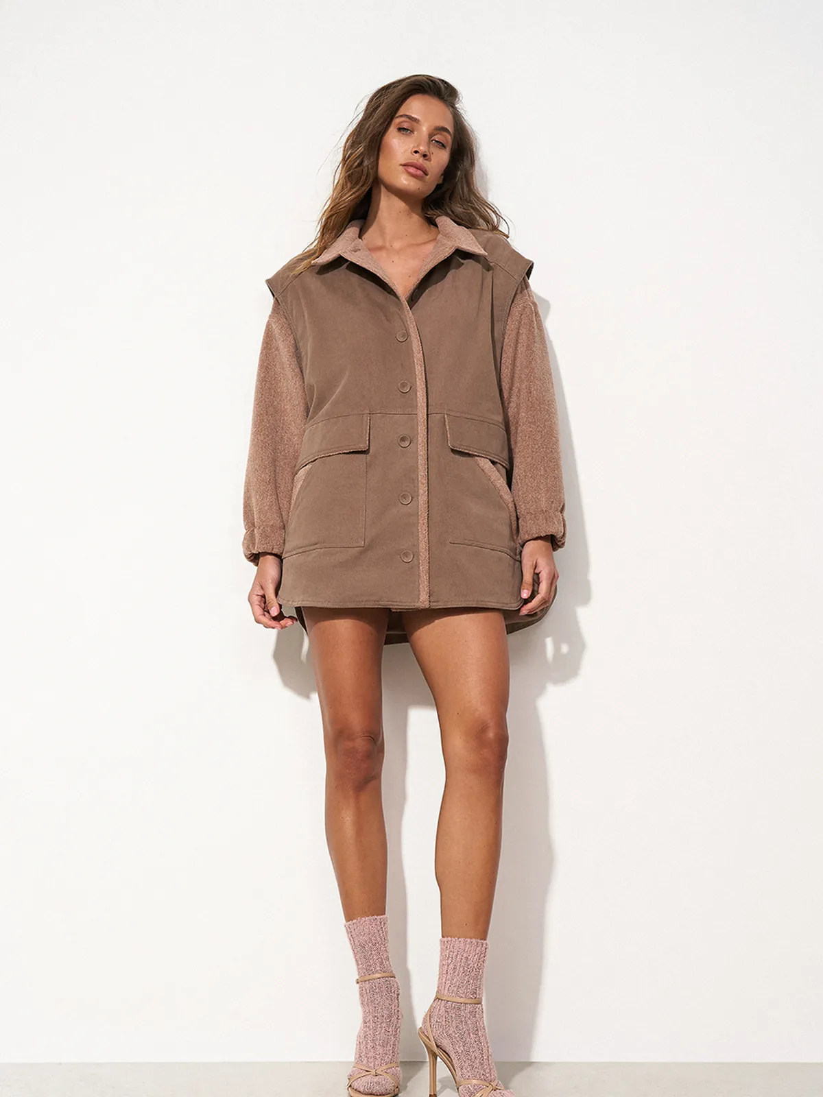 Улыбающаяся женщина в коричневой рубашке оверсайз SHIRT COSY CHOCOLATE от MOODSTORIES с фактурными рукавами и воротником.