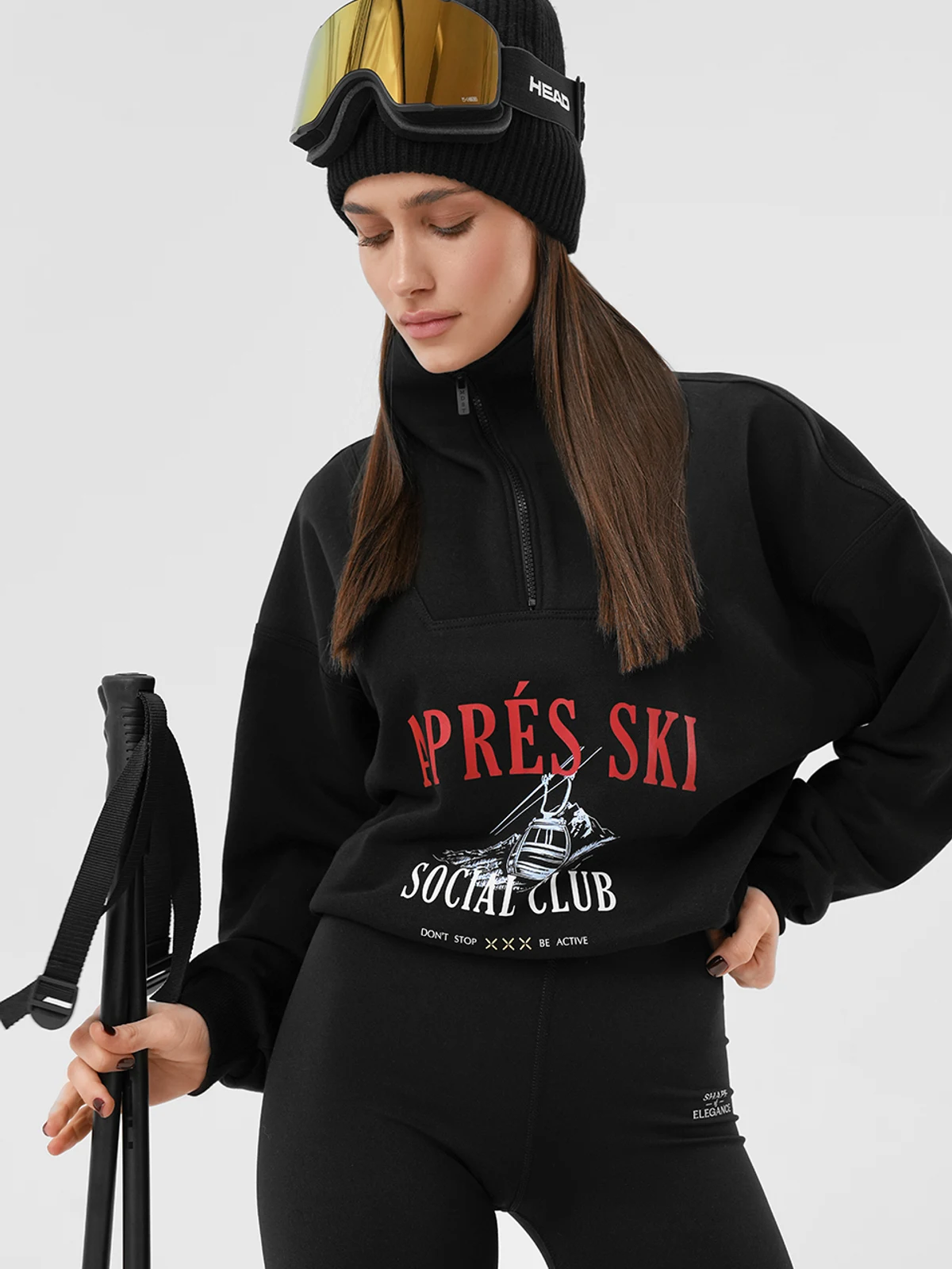Дівчина в чорному костюмі MOODSTORIES SUIT Le Club Après Ski: світшот з принтом та широкі штани з написом.