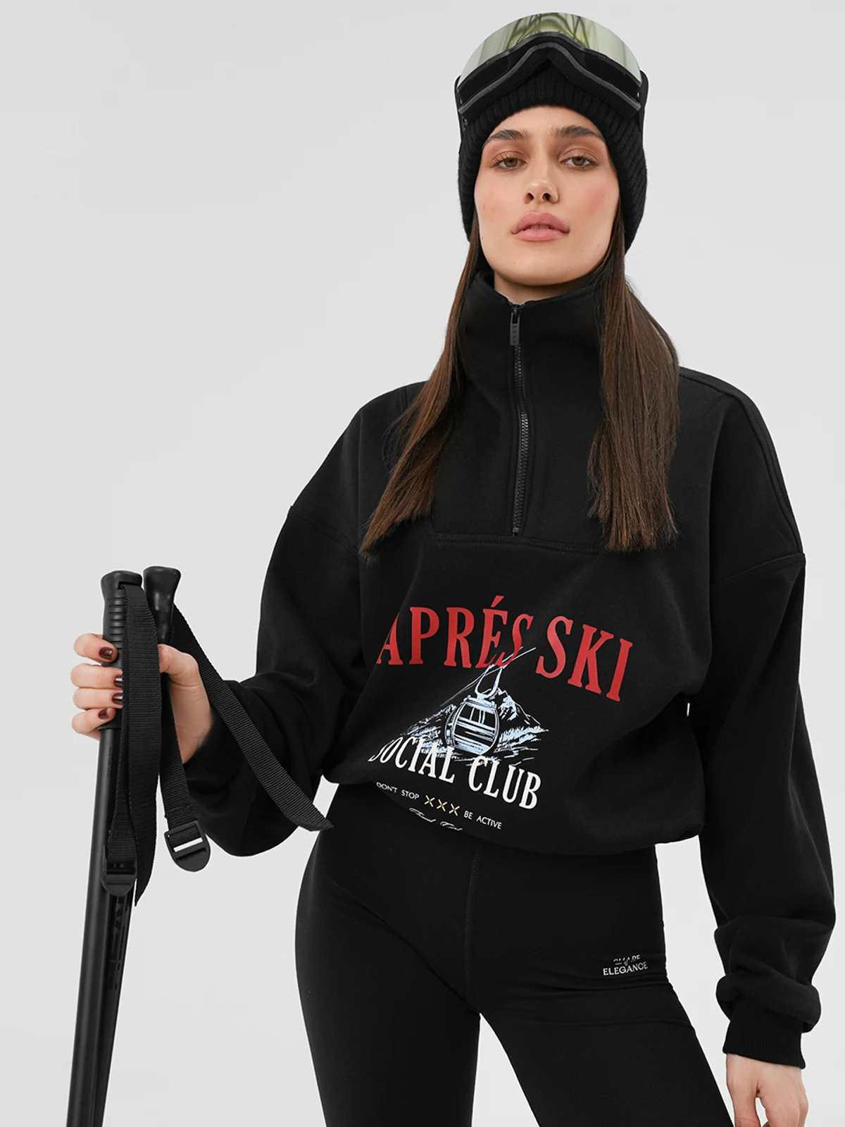 Дівчина в чорному костюмі MOODSTORIES SUIT Le Club Après Ski: світшот з принтом та широкі штани з написом.