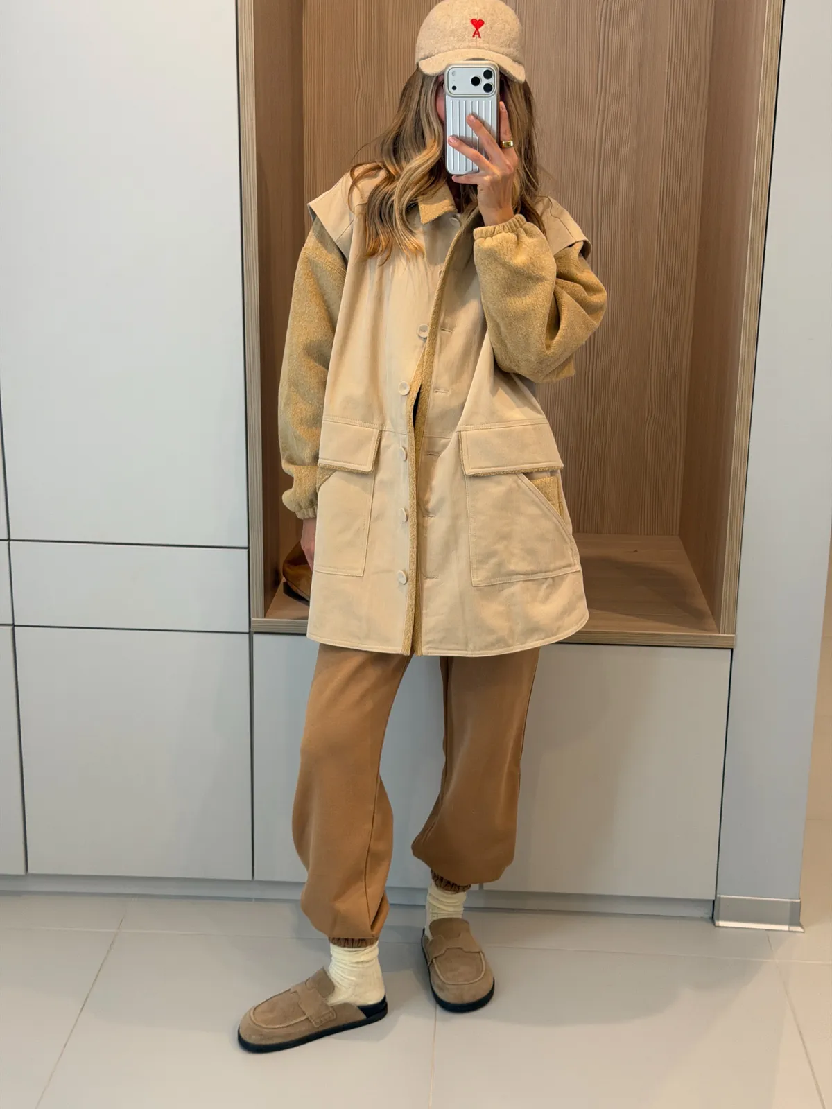 Модель в удлиненной рубашке-куртке SHIRT COSY LATTE от MOODSTORIES бежевого цвета с фактурными рукавами и карманами.