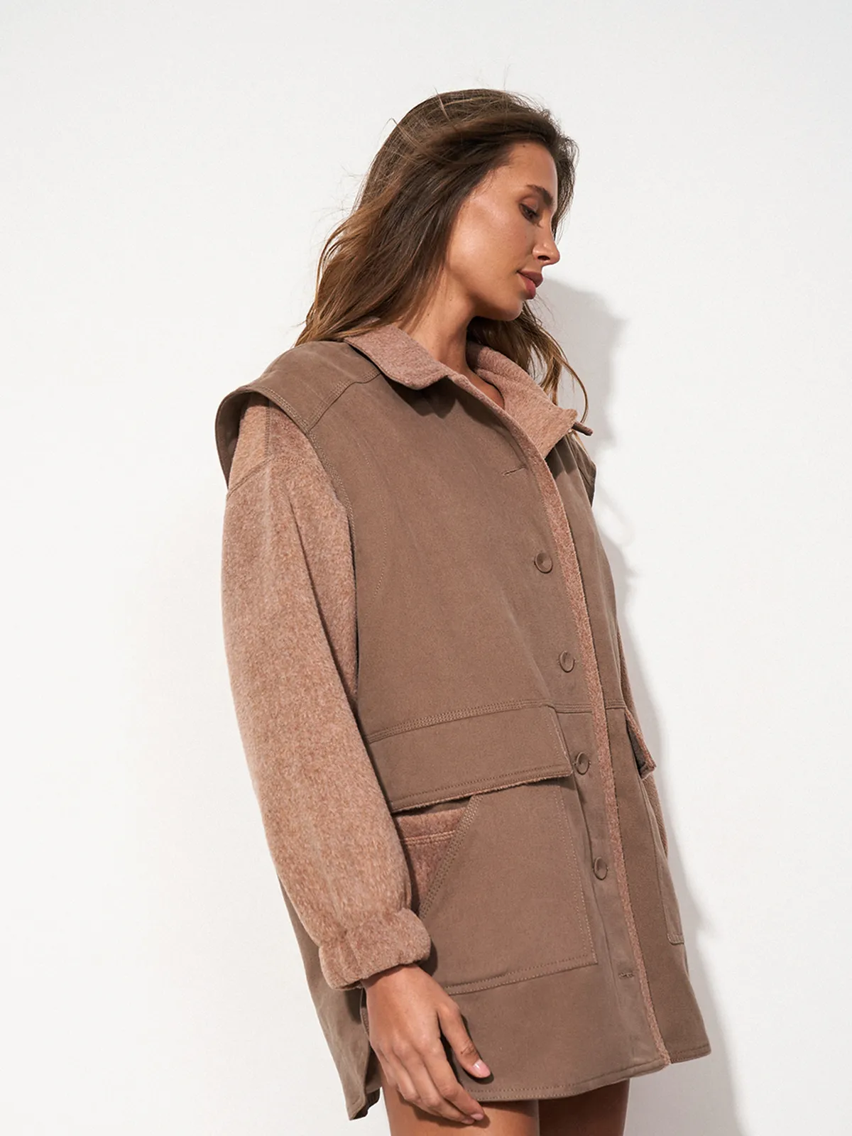Улыбающаяся женщина в коричневой рубашке оверсайз SHIRT COSY CHOCOLATE от MOODSTORIES с фактурными рукавами и воротником.